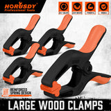 Pack of 4 HORUSDY 7-inch black nylon spring clamps with orange non-slip TPR handles and reinforced glass fiber construction for secure clamping.